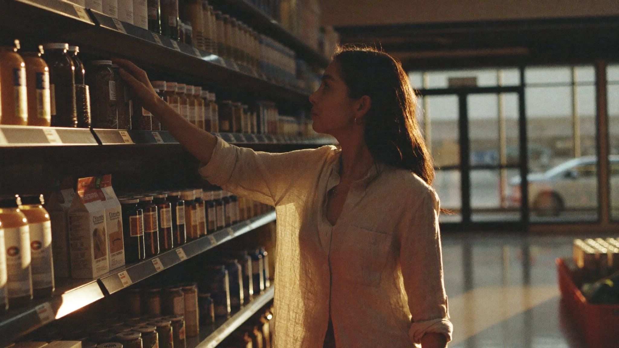 A shopper reaching for a product in warm evening light